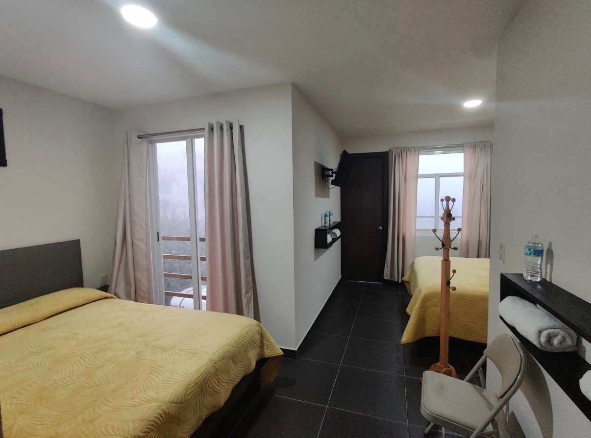 Deluxe Doble con dos camas matrimoniales y vista del área principal.